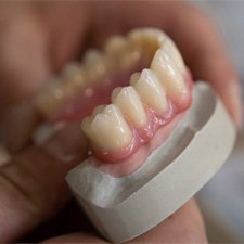A dentist holding a denture mouth mold  