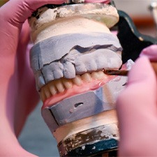 A lab technician creating a set of dentures   