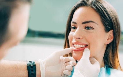 Dentist examining patient's smile after periodontal therapy