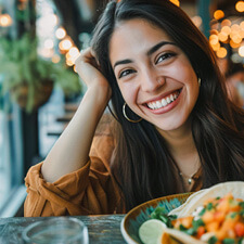 Smiling woman eating at restaurant