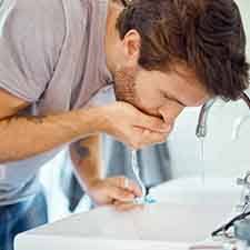 a man rinsing his mouth after scaling and root planing