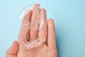 Open palm holding two clear aligners