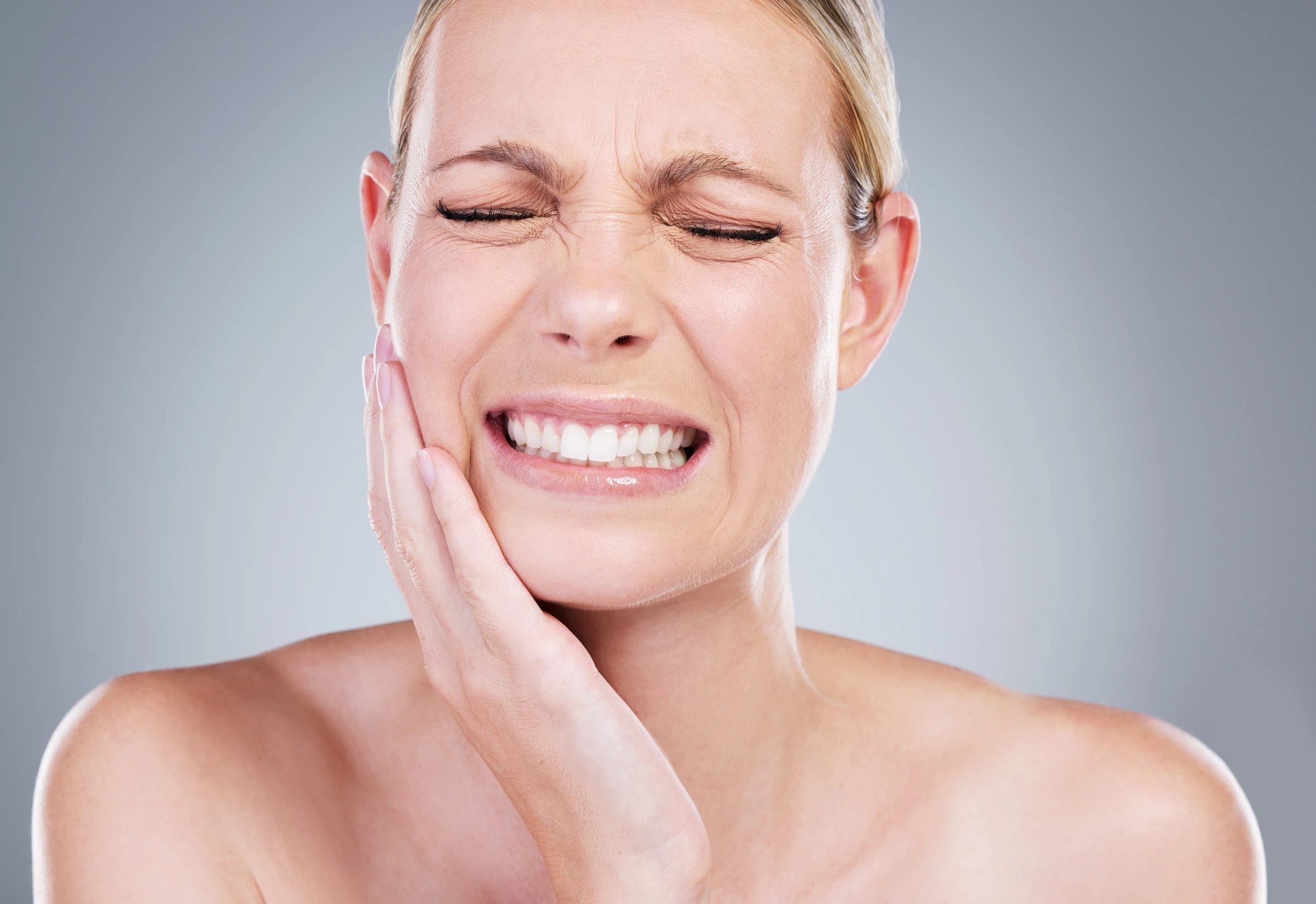 Woman-experiencing-severe-tooth-pain-holding-jaw-indicating-dental-emergency-in-Richmond