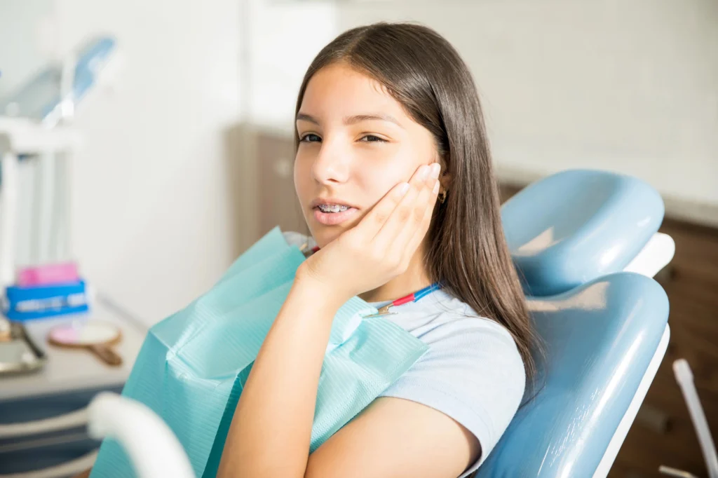 Woman holding her face in pain at the dentist in Short Pump VA