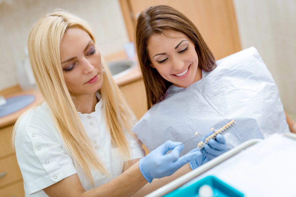 dentist-showing-patient-different-crown-options-cosmetic-dentists-Richmond-VA